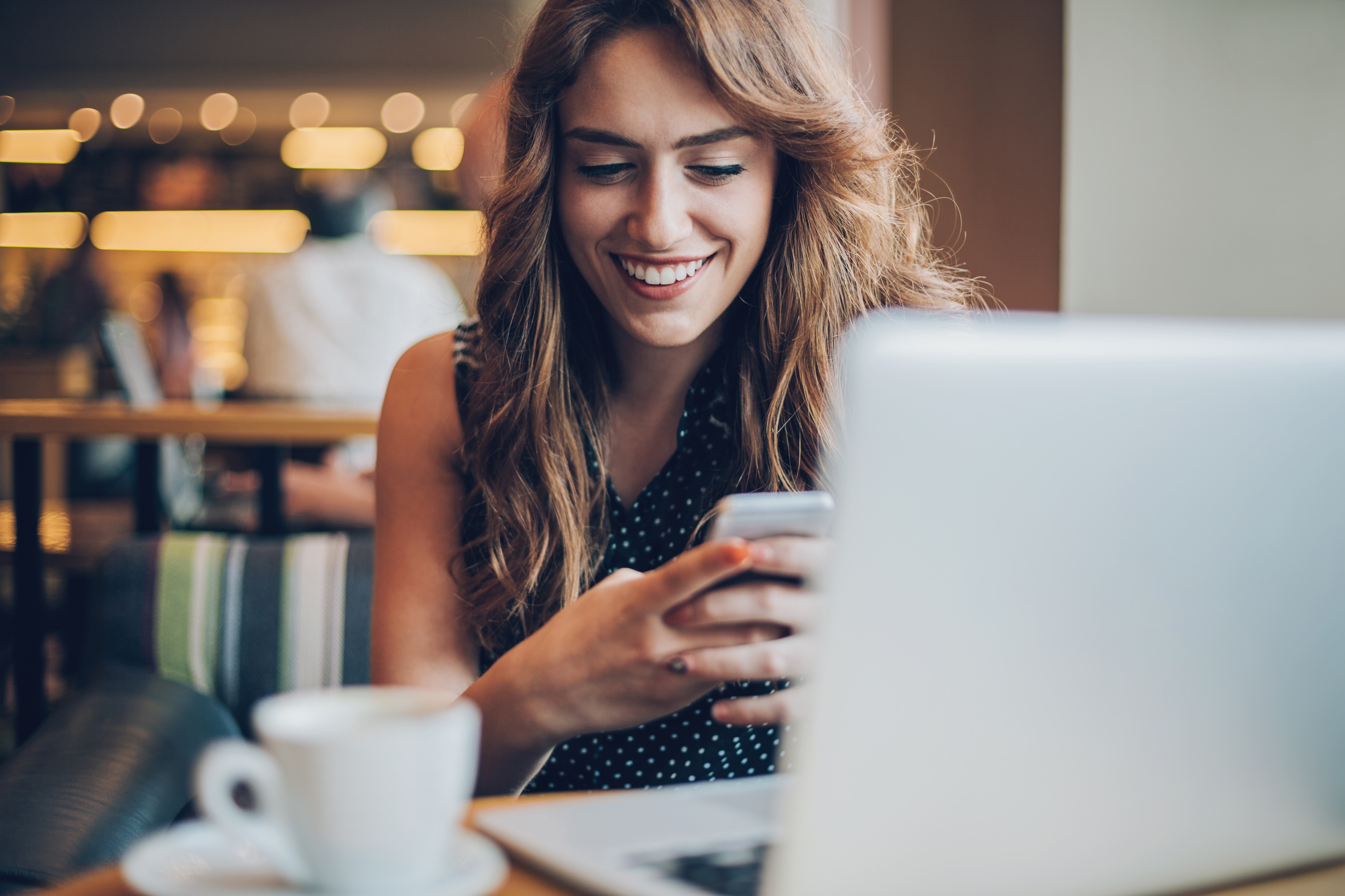 woman at a coffee shop working on a laptop